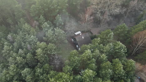 antigua casa histórica rodeada de pinos verdes filmada con un dron desde arriba en un día nublado en bartoszylas polonia