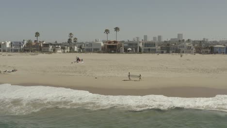 Beautiful-aerial-drone-of-California-coastal-beach-with-surfers---Ungraded