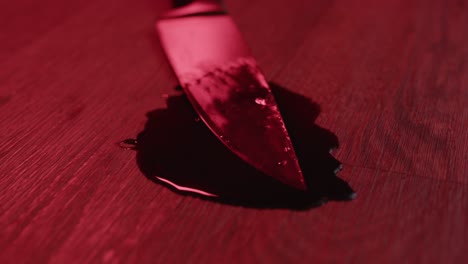 medium view of a blood covered knife in a puddle of blood on a grizzly crime scene