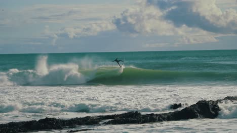 surfer getting barrelled in an overhead wave in cornwall, uk. nice beach view