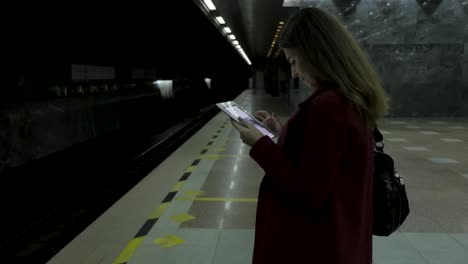 woman using tablet in a dark subway station