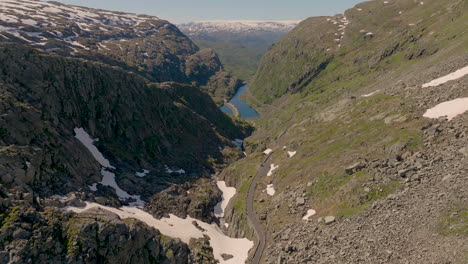 por encima de un paso de montaña cubierto de nieve que desciende desde la cumbre hasta el río en el valle