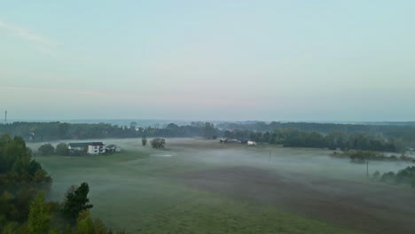 flying above the plain landscape with foggy morning mist in the forested area