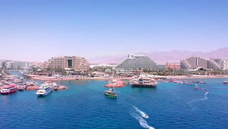 aerial view of a bustling coastal resort city with boats in the bay