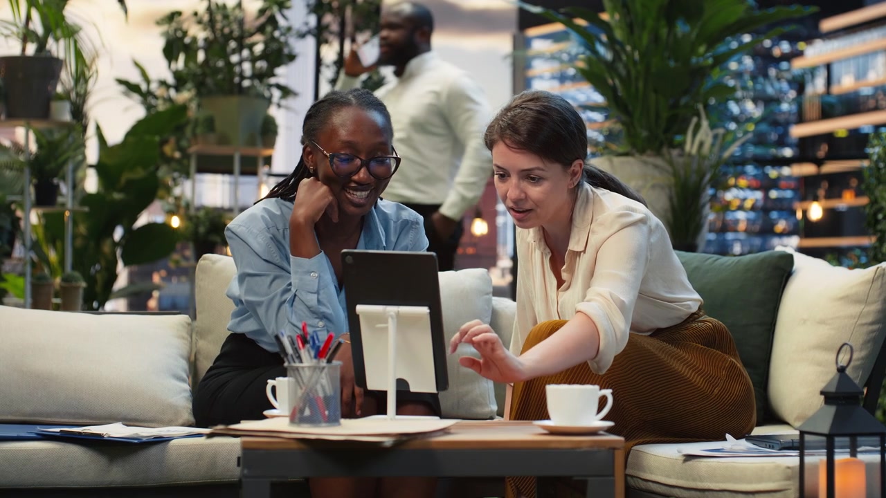 Company coworkers looking at tablet screen on stylish rooftop workspace