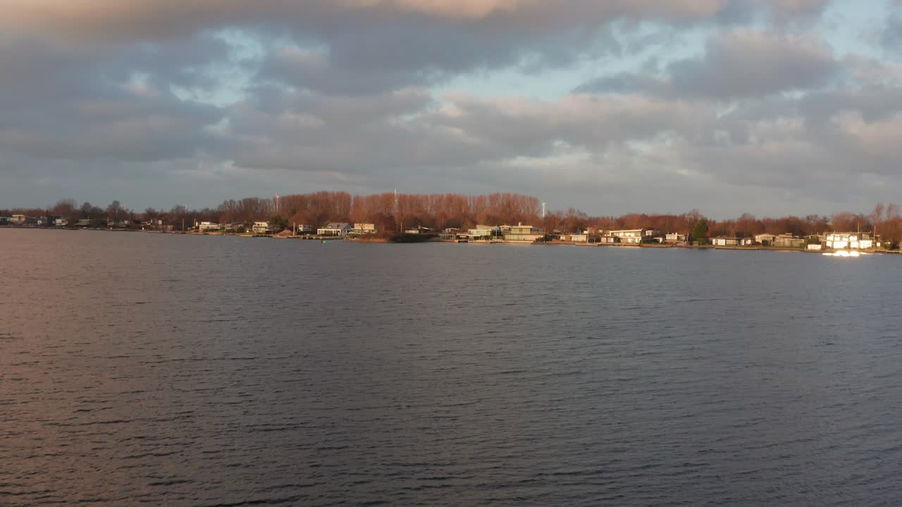 Vacation homes located at a lake during winter. Forward flying drone shot