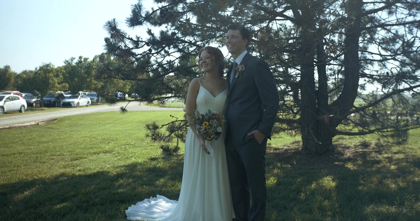 Una sposa e uno sposo felici e sorridenti in posa per le foto all'aperto presso la location del matrimonio