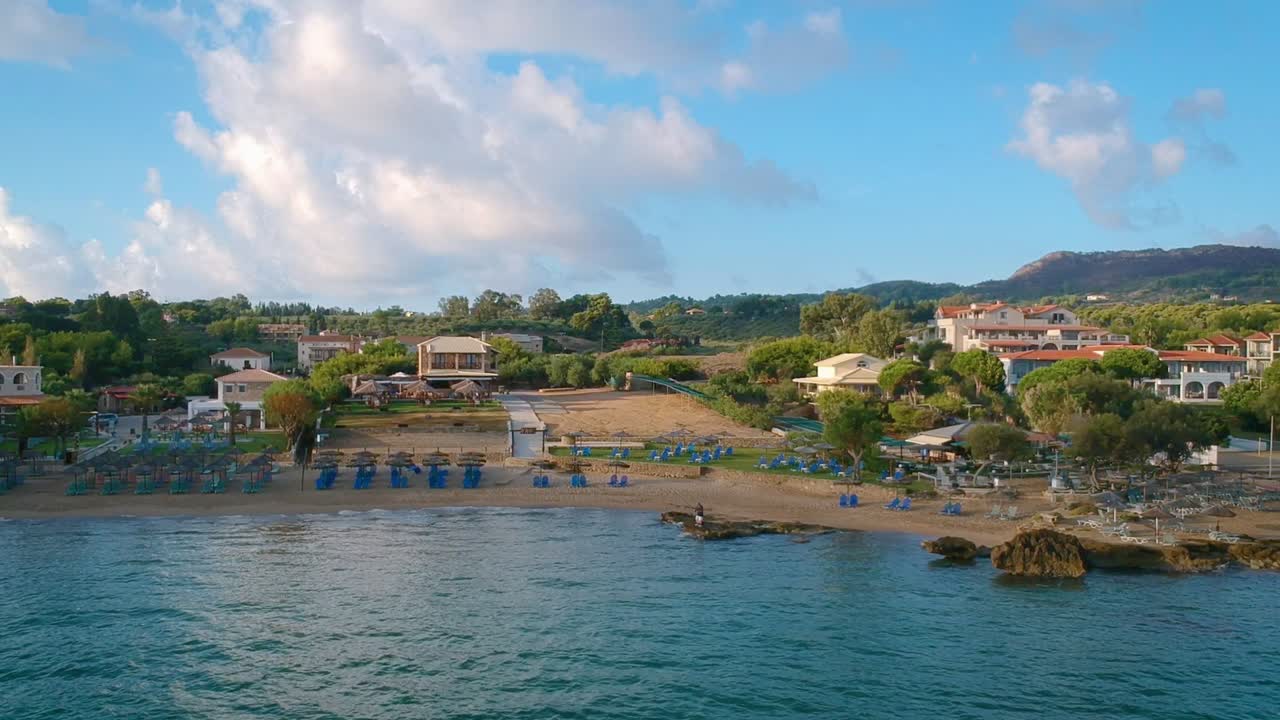 panorámica aérea a través del mar con vistas a la costa con tumbonas y complejos hoteleros en zakynthos, grecia
