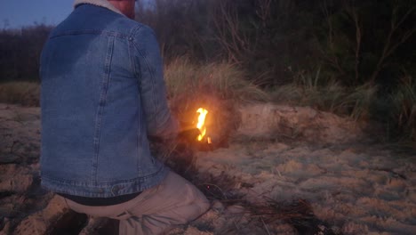 Ein-Mann-Entzündet-Am-Frühen-Morgen-In-Südaustralien-Am-Strand-Ein-Feuer-Mit-Bushcraft-Methoden