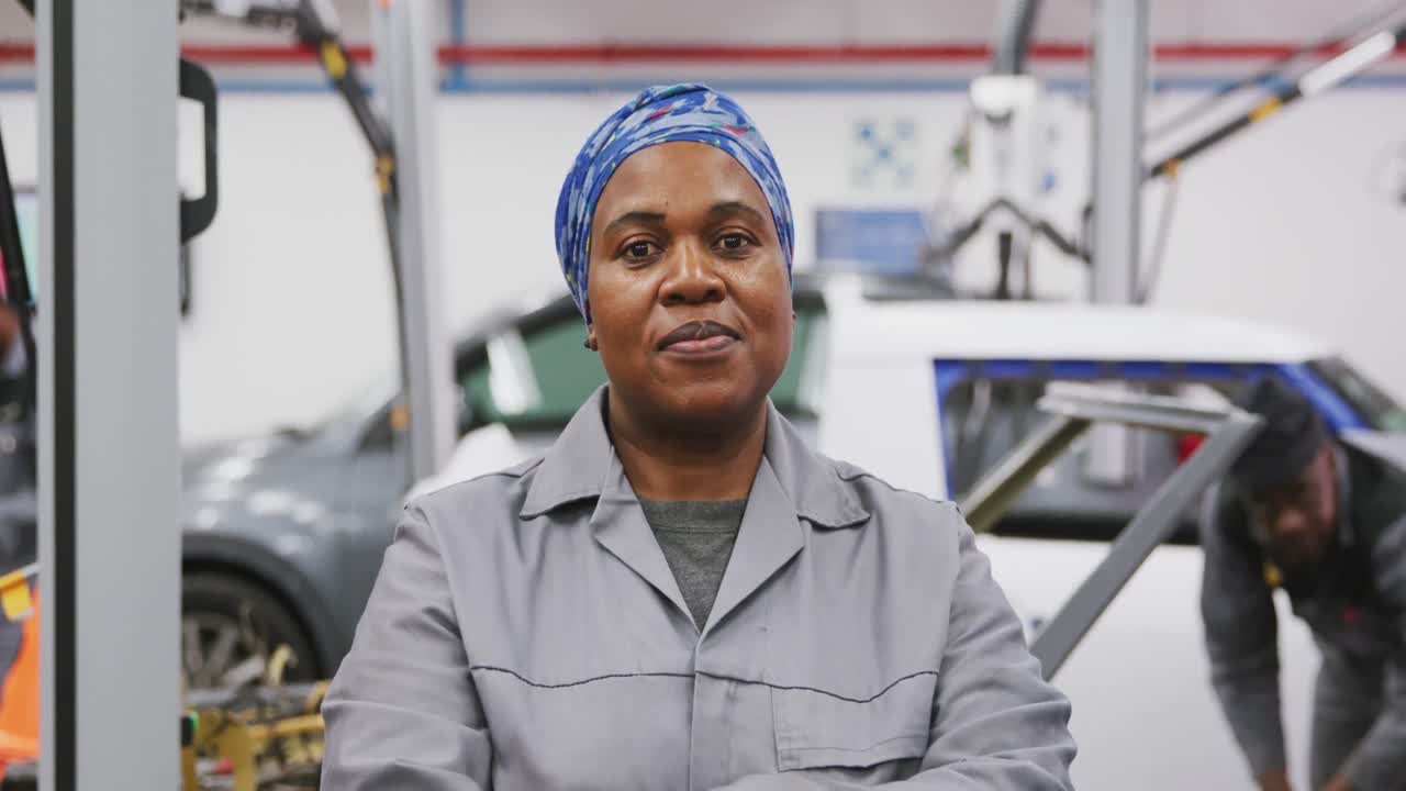 African American female car mechanic crossing her arms and looking at camera