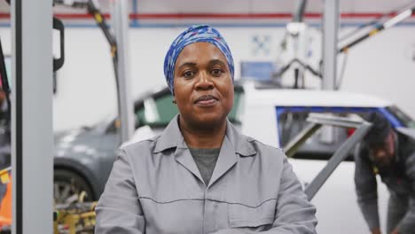 african american female car mechanic crossing her arms and looking at camera