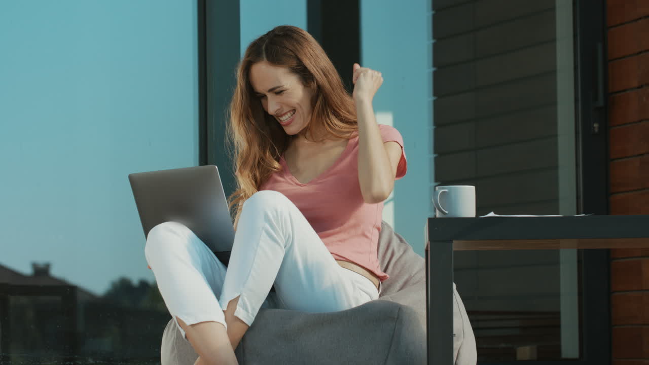 mujer feliz trabajando con una computadora portátil fuera de casa. mujer de negocios haciendo la victoria.