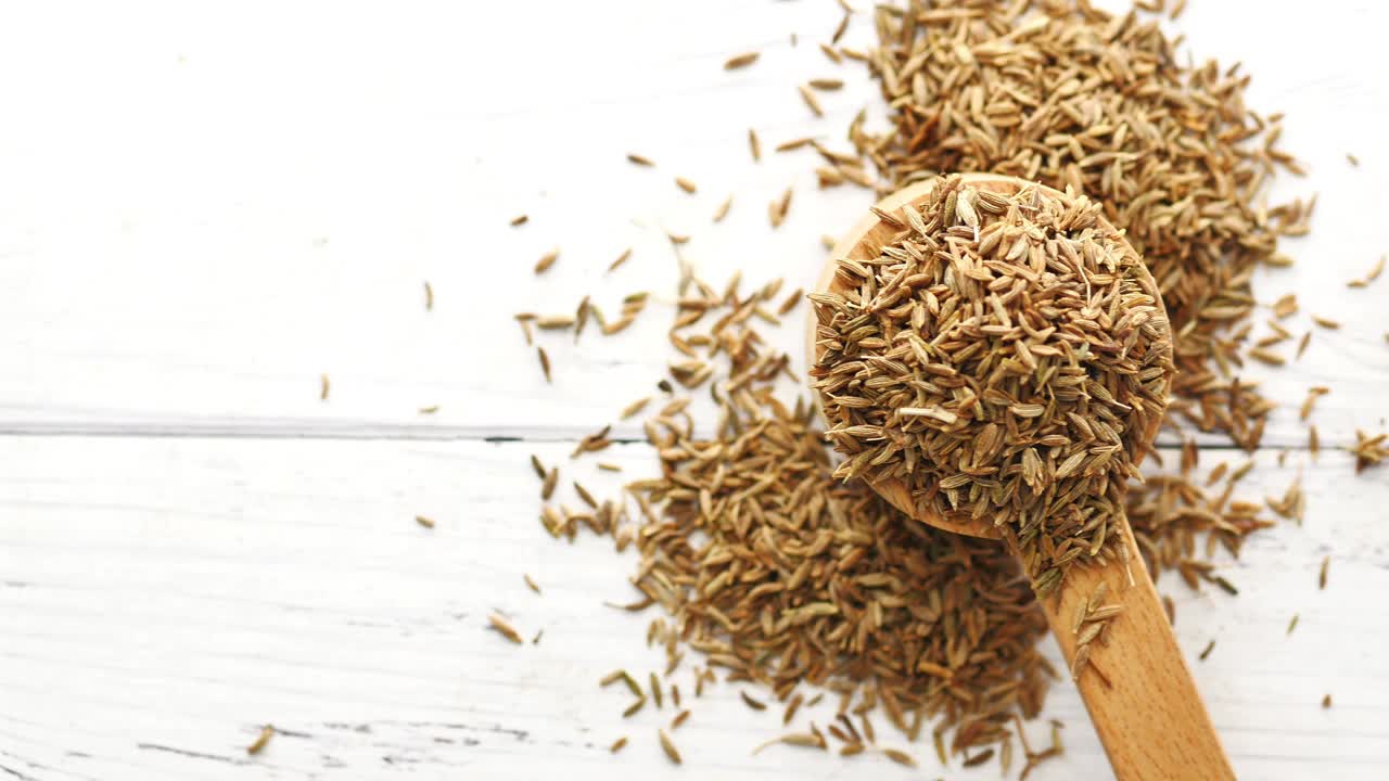 Cumin seeds on spoon on table
