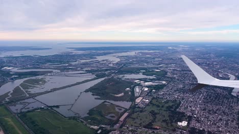 avión volando sobre nueva jersey con la isla de manhattan en la distancia