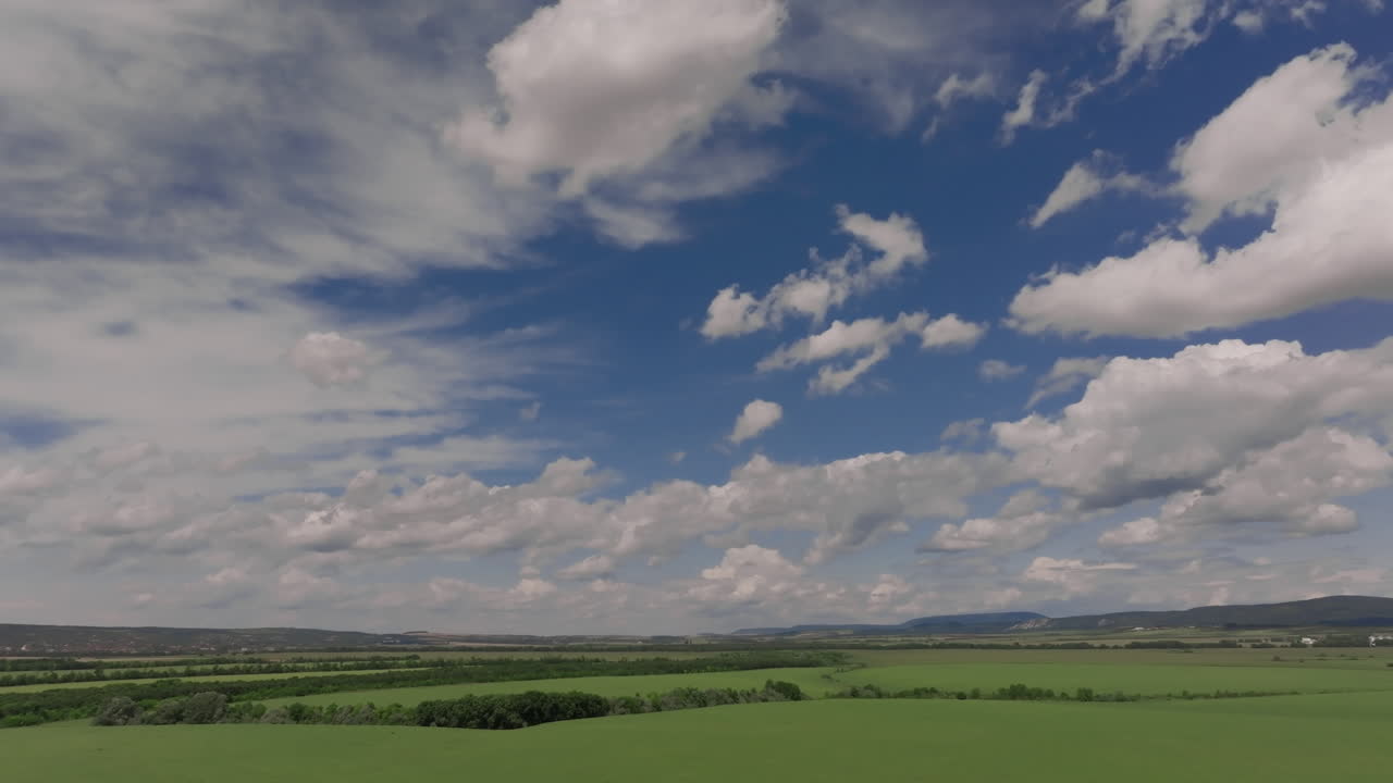 vista aérea de un campo verde con cielo azul y nubes blancas