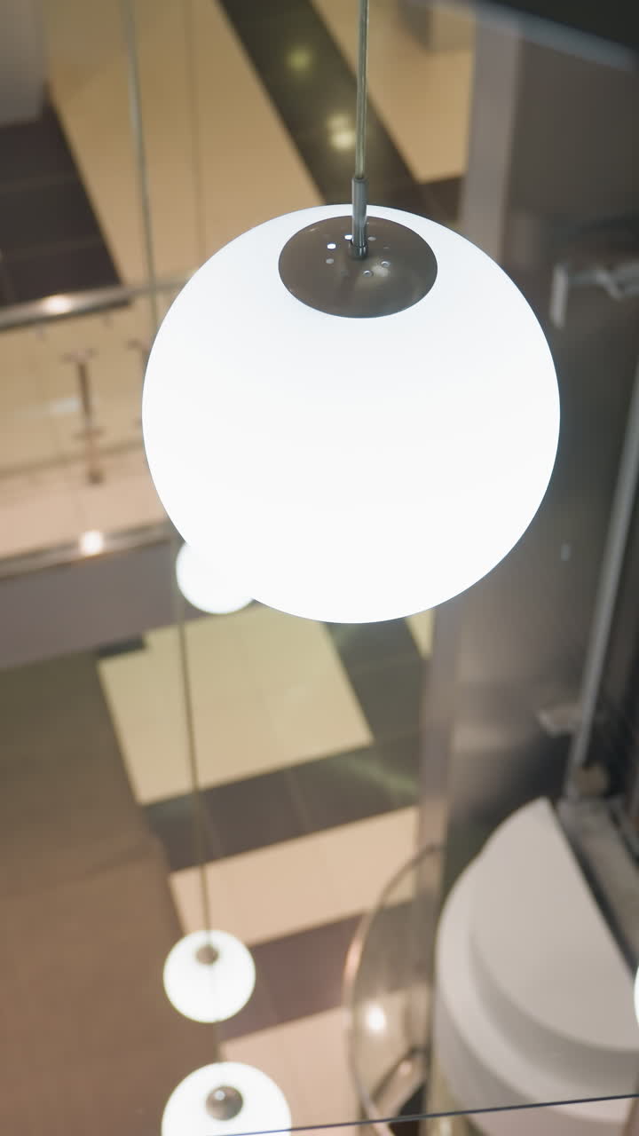 vista en primera persona capturando la escalera con barandillas de vidrio modernas y el entorno interior circundante. la cámara se centra en el diseño elegante de las escaleras y el fondo brillante y decorado