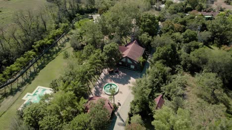 vista aérea de la pintoresca casa con la piscina, rodeada de naturaleza