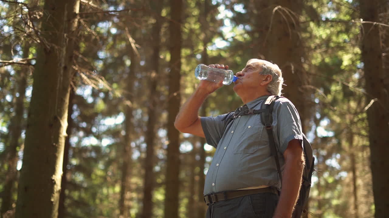 Senior Man Drinking Water in Forest