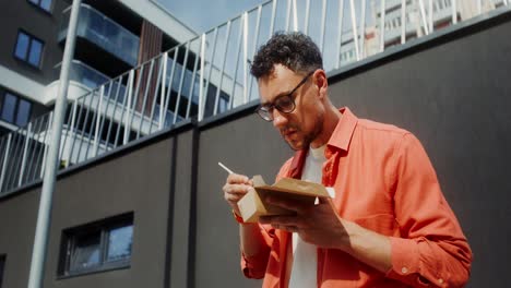 hombre comiendo fideos afuera