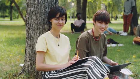 portrait of two cheerful college girls in park