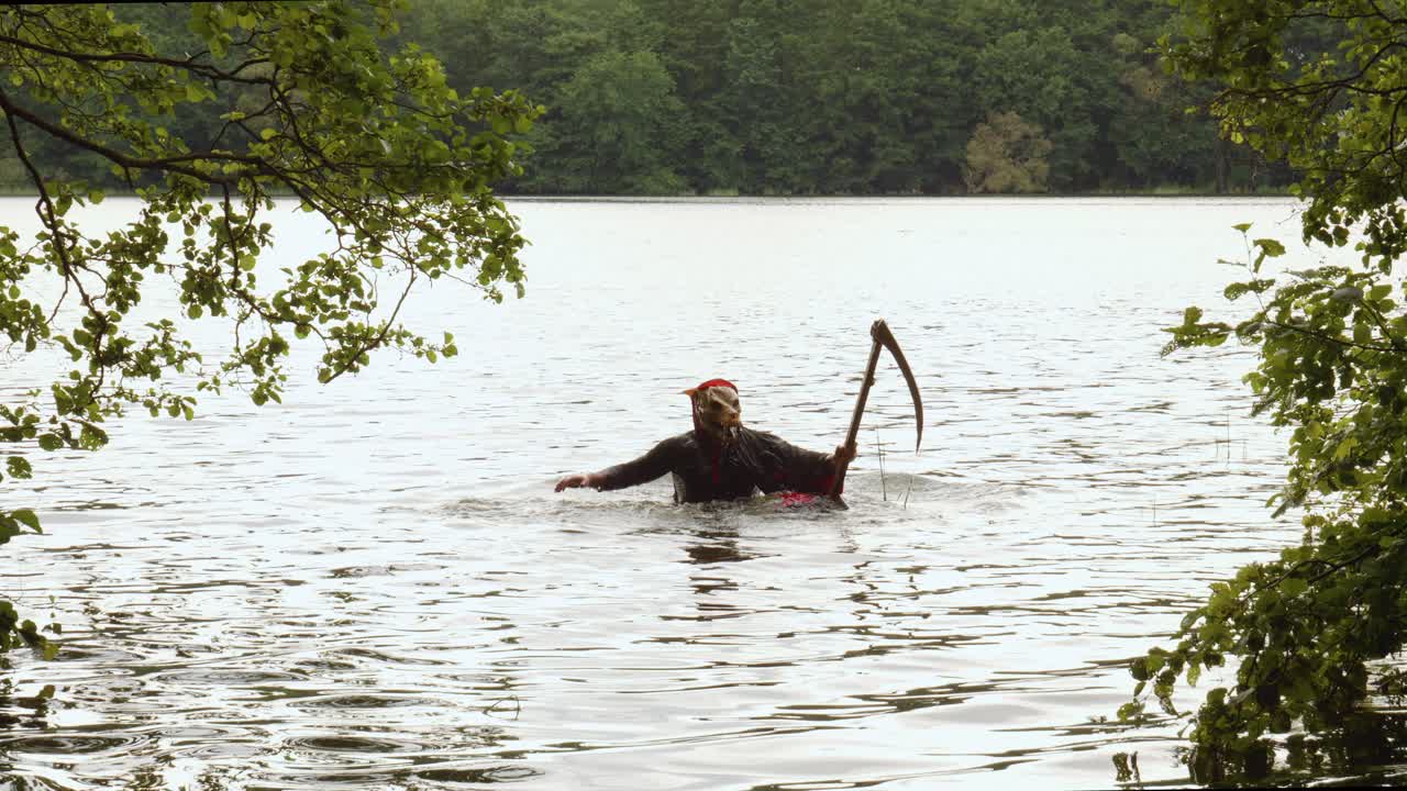 Grim Reaper With Scythe Emerge From The Water In The Lake