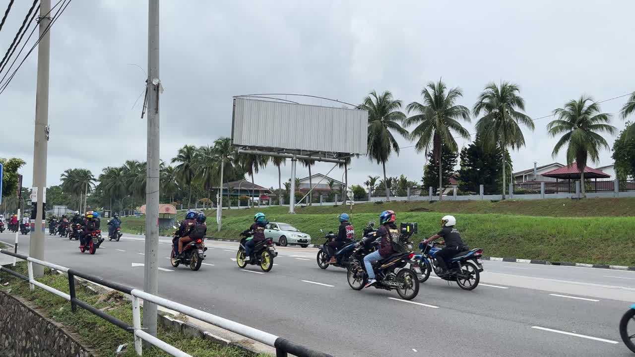 Scooter and motorbike traffic in Port Dickson Malaysia main road day time