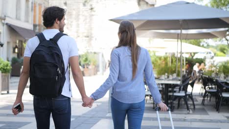 cheerful young couple on cultural weekend city trip discovering together historical european city in summer