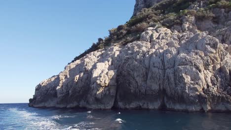 travel shot of the famous capri stacks, the symbol of the island, located in the gulf of naples - italy