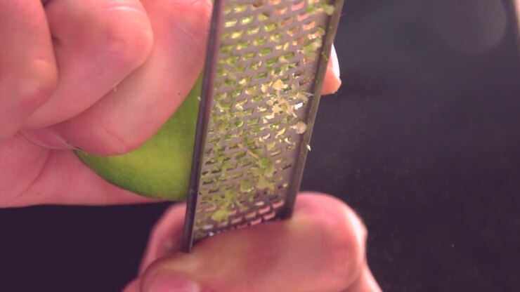 Cook grating fresh lime in kitchen