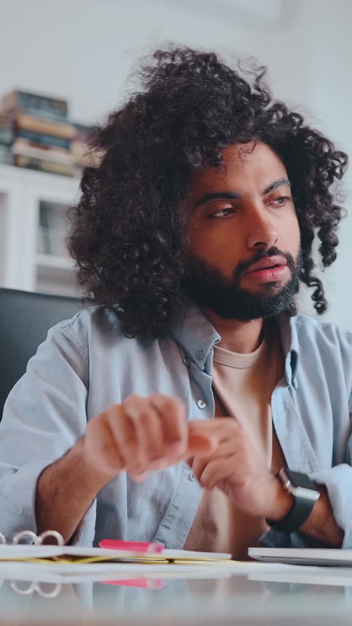 Focused man working intently on laptop in a cozy home office setting