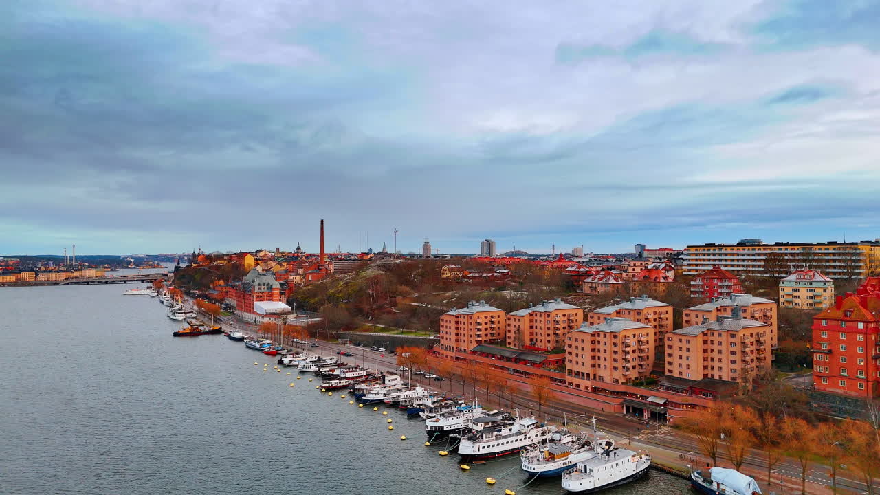 Diverse imbarcazioni si trovano ormeggiate sulla banchina del lago Malar. Filmato lungo lo skyline di Stoccolma, Svezia in una giornata cupa.