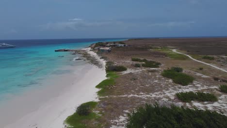 aerial overview of windy beach with sand volleyball court and palm trees
