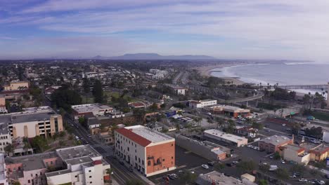 aerial wide reverse pullback shot of downtown ventura, california along the coast