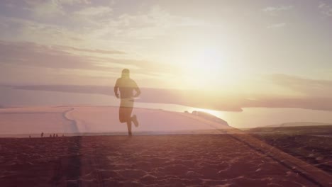 composite of man jogging on sand with sunset over beach and sea