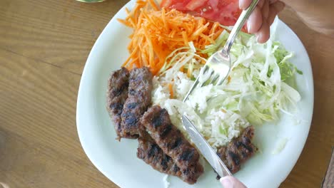 eating köfte with rice and salad