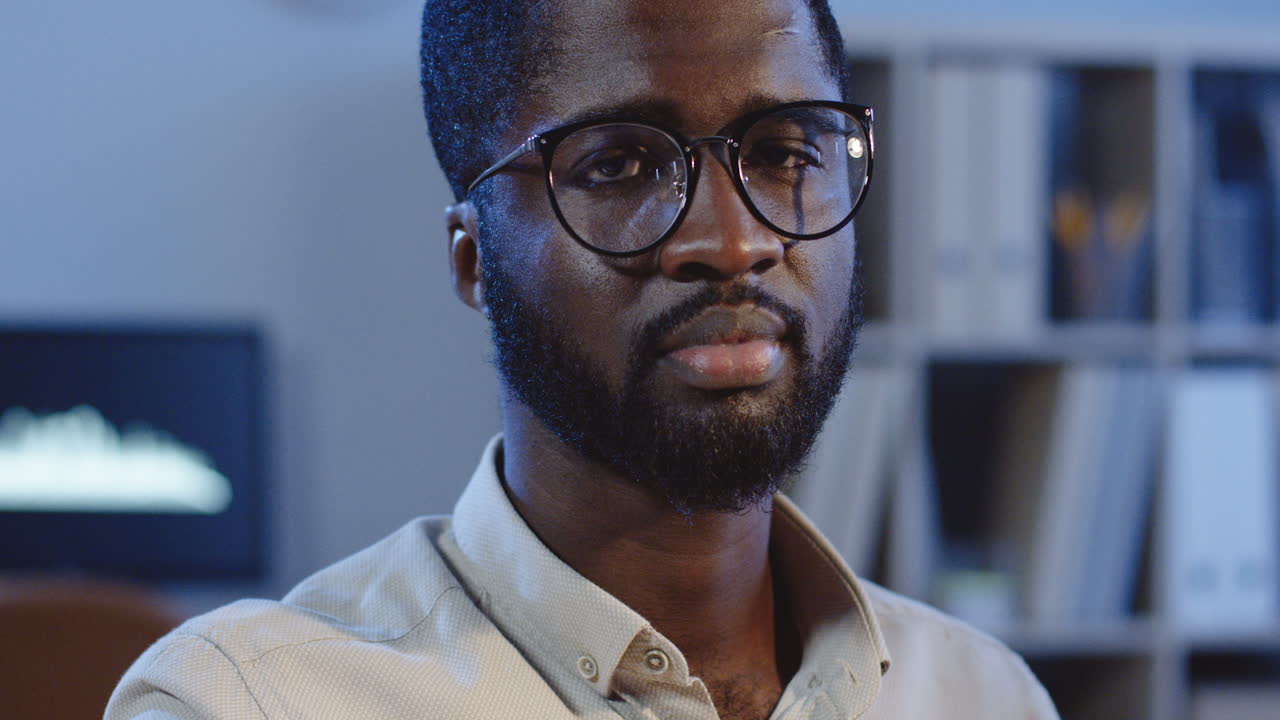 Close Up View Of The Joyful Man Smiling To The Camera In The Office At Night