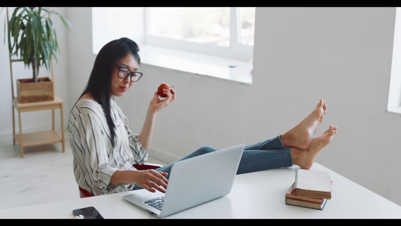 Woman Working From Home, Eating an Apple