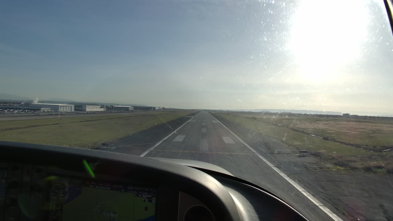 Punto di vista del pilota: Atterraggio di un aereo a elica su una pista in una giornata di sole.