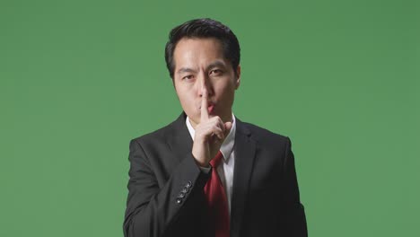 businessman making a shushing gesture