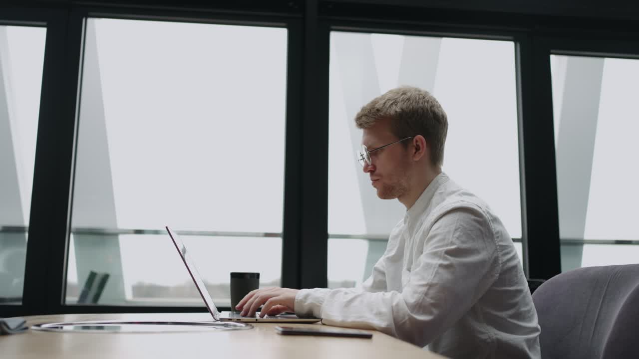 프리랜서 프로그래머 또는 번역가는 카페 또는 공동 작업 공간에서 노트북으로 키보드에 텍스트를 입력하고 있습니다.