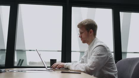 programador o traductor independiente está trabajando con una computadora portátil en un café o espacio de coworking, escribiendo texto en el teclado