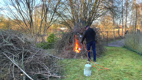 un hombre enciende una gran hoguera en un prado