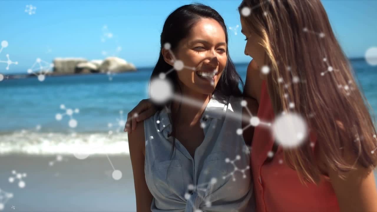 Two women walking on sunny beach, molecular health overlay entering frame and highlighting bond