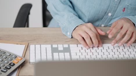 close up hand of a business woman typing keyboard desktop computer on desk office