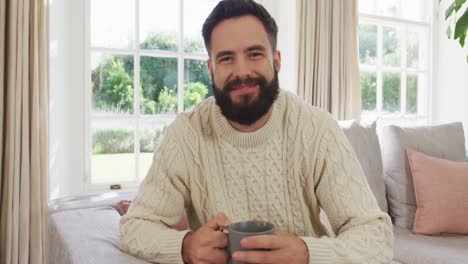 Video-of-happy-caucasian-men-siting-on-sofa-and-drinking-coffee