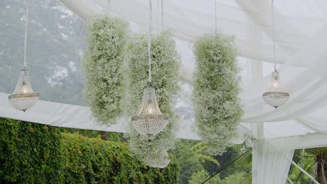 elegant chandeliers and floral arrangements hang from the ceiling of a beautiful white tent set for a formal evening in antigua, guatemala