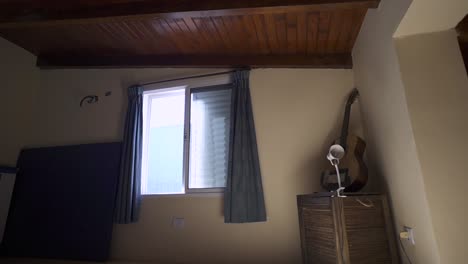 minimalist room with warm wooden ceiling, white walls, and practical storage. window provides natural light. ideal for rental listings.
