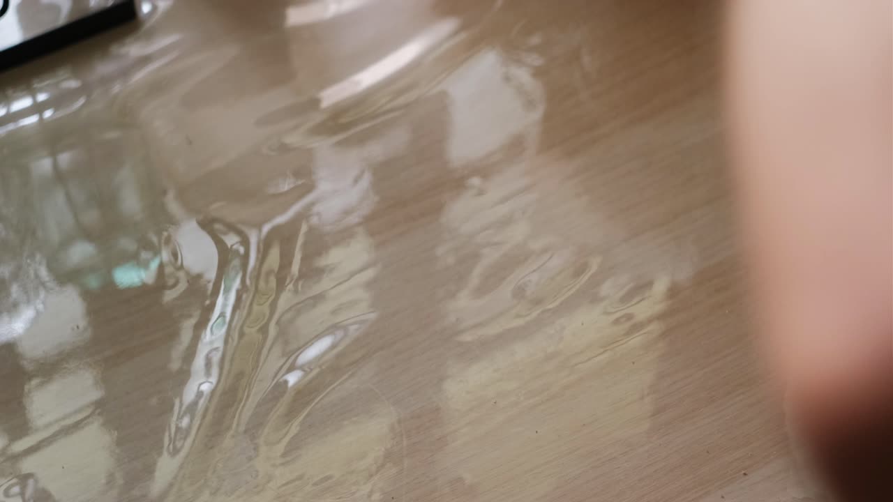 Close-up shot of protein powder being poured into shaker bottle on kitchen table