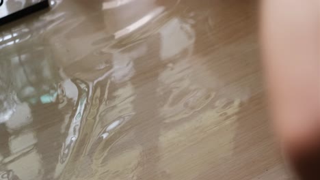 close-up shot of protein powder being poured into shaker bottle on kitchen table