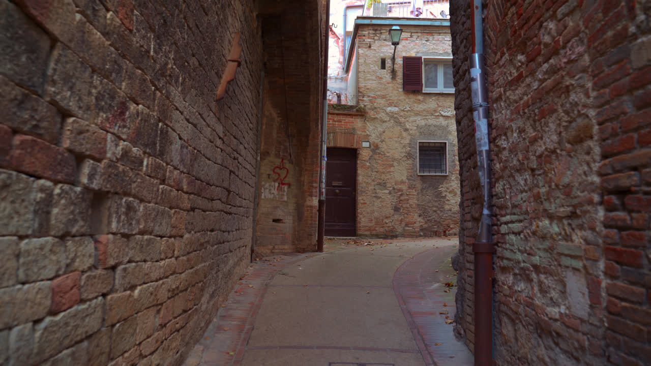 Narrow stone alleyway with arches and soft morning light in Perugia historic center